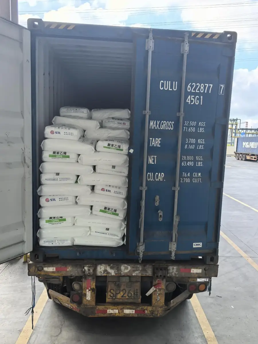 Shipping container loaded with 25 kg GPPS resin bags, doors open on the truck before sealing